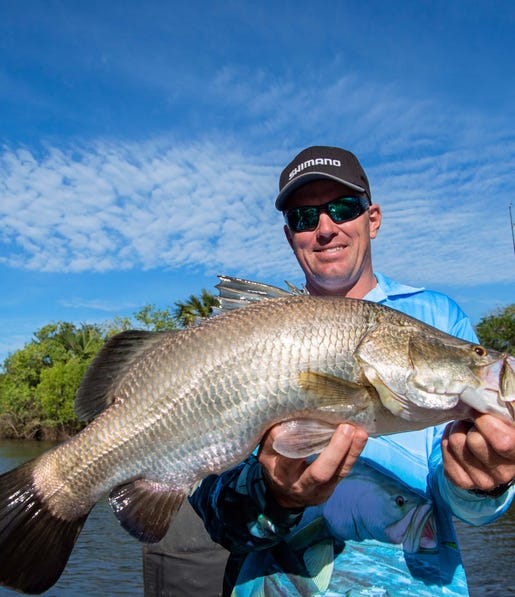 A man holding a Barramundi