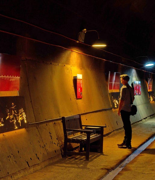 Visitor reading the display in the WWII Oil Tunnels at the Darwin Waterfront